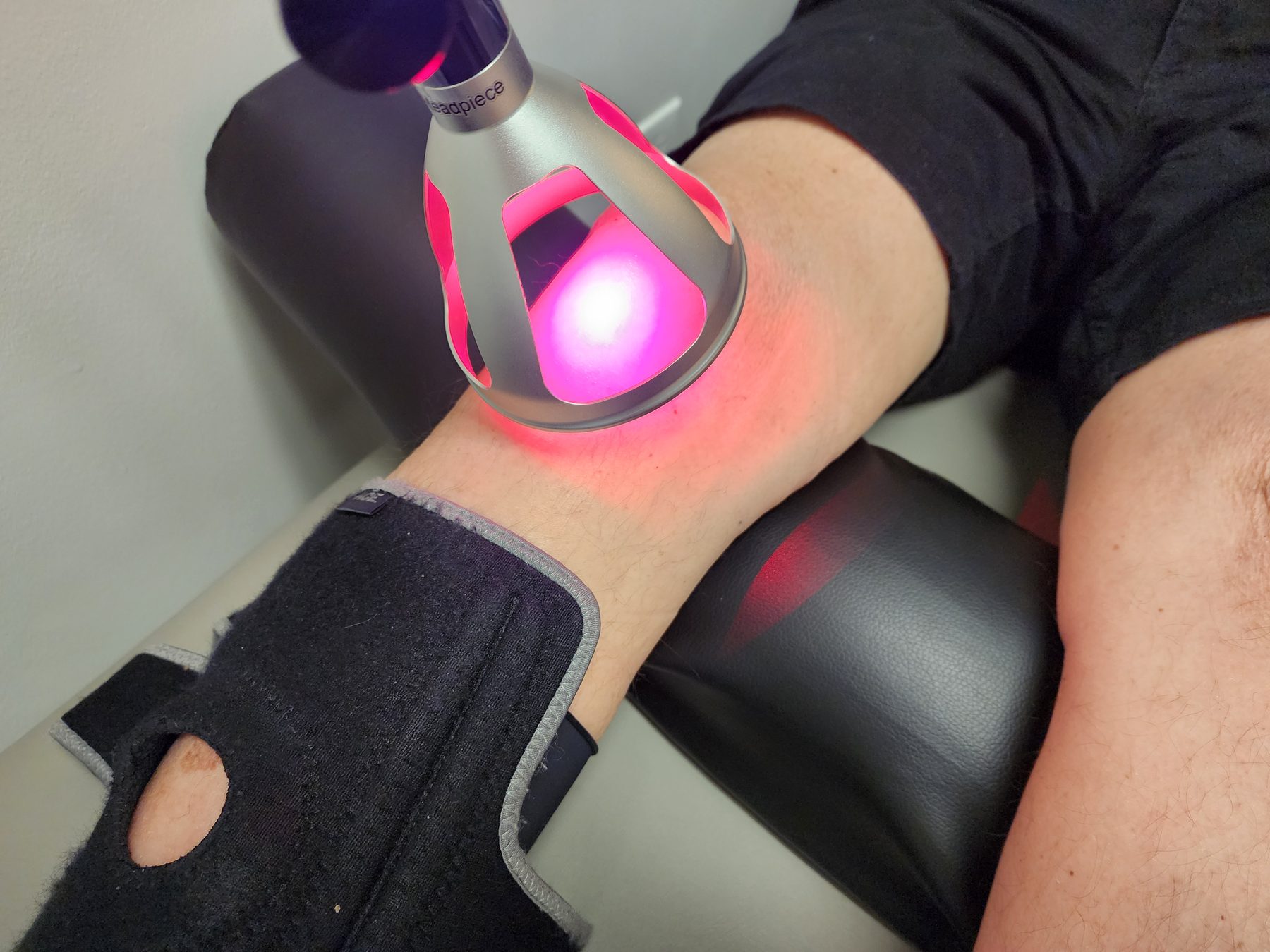 Class IV cold laser being applied to a patient's knee at Bonesetters in Chesterfield, MO